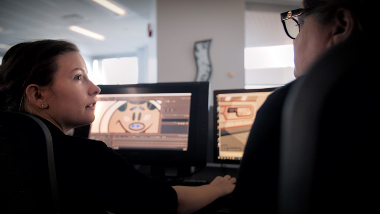 An Animator and her Supervisor from Mercury Filmworks look at each other talking as they look over a cintiq.